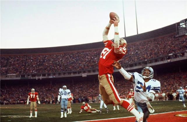 Simplemente, "The Catch". Dwight Clark ya atrapó el balón para darles a los 49ers en Candlestick Park el primer título de la NFC y los pasajes al Super Bowl.