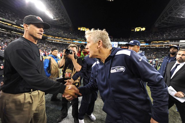 Jim Harbaugh (izquierda) y Pete Carroll. El saludo entre los entrenadores es obligatorio en la NFL, por lo que esta imagen no indica cariño o respeto entre ambos. (Foto Sports Illustrated)